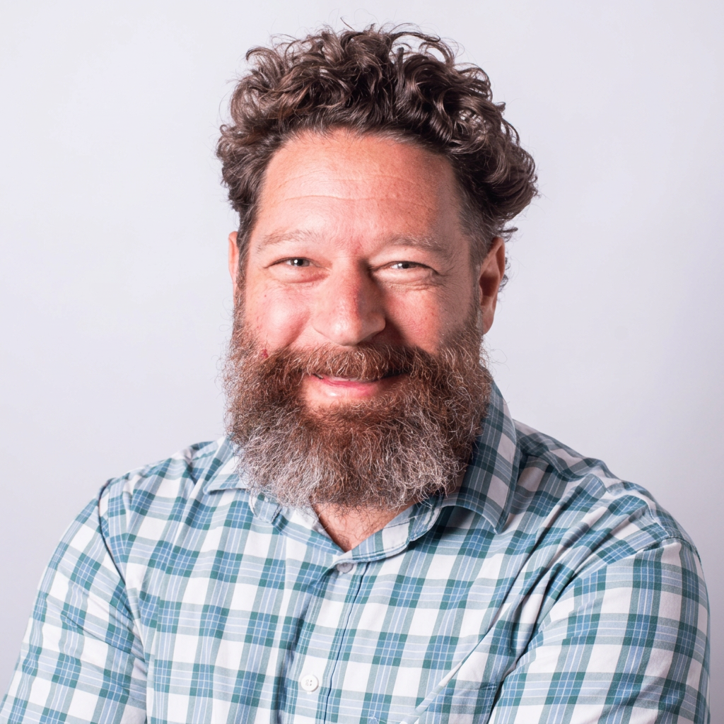 Adam Berk smiling at the camera in a head-and-shoulders portrait
