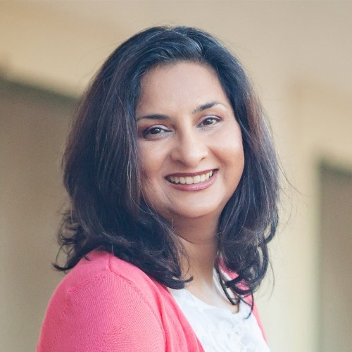 Kavita Appachu smiling at the camera in a head-and-shoulders portrait